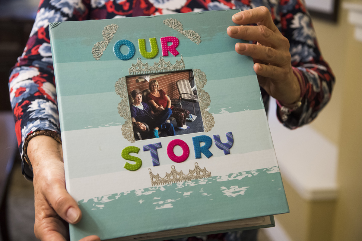 Kathy Kirkland holds a scrapbook she made from her mother, Joan Harrison, at Brookdale retirement home in Cedar City on March 16. Harrison gave Kirkland up for adoption 60 years ago, and Kirkland made contact with her last year.